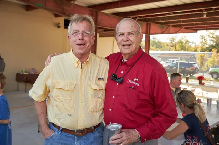 Two men embracing one another for photo